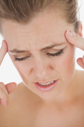 Young unhappy woman with severe headache over white background