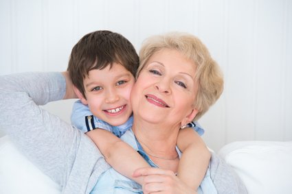 Lovely little boy with his grandmother having fun and happy mome