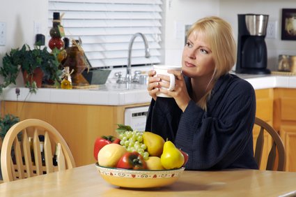 Contemplative Woman in Kitchen with Cup of Coffee.