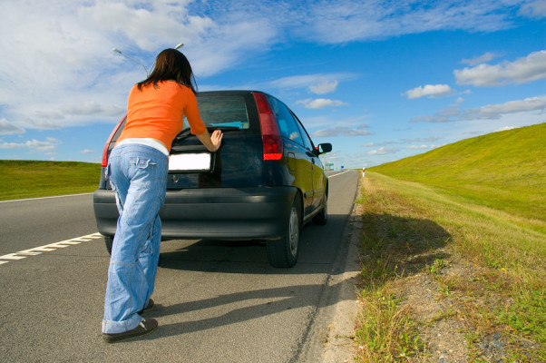woman pushing a car