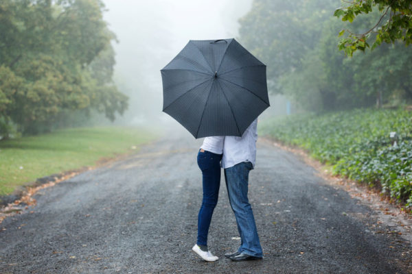 37930541 - couple kissing behind the umbrella in the mist